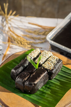 Traditional Indonesian Black Glutinous Rice Dodol Cake on Banana Leaf with Sesame Topping (Jenang Ketan Hitam)