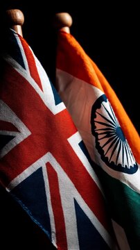 british flag waving next to indian flag on black background. relations great britain and india