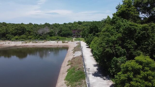 man riding a scooter near a reservoir on koh samet island, thailand, digital nomad