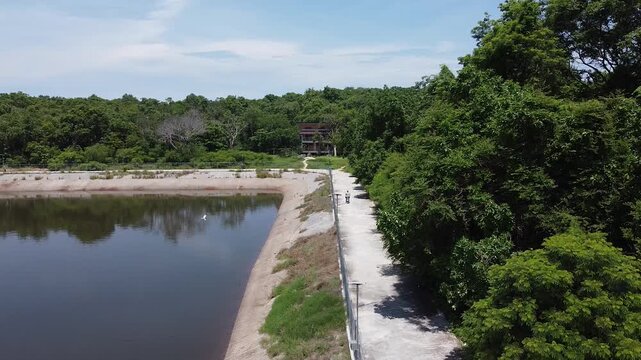 man riding a scooter near a reservoir on koh samet island, thailand, digital nomad