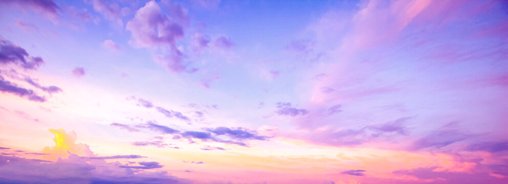 Beautiful vibrant twilight sky background with colorful pastel pink purple and blue clouds at sunset for inspirational nature wallpaper panorama