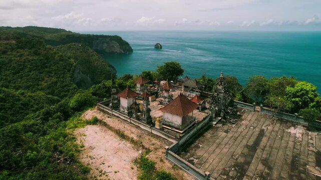 Aerial Drone View of Uluwatu Temple Pura Luhur Built on a Steep Cliff Edge Overlooking the Ocean in Bali Indonesia, Iconic Hindu Sea Temple, Cultural Landmark Travel Tourism Concept
