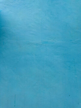 Expansive cyan facade showcasing nuanced organic textures in ambient light
