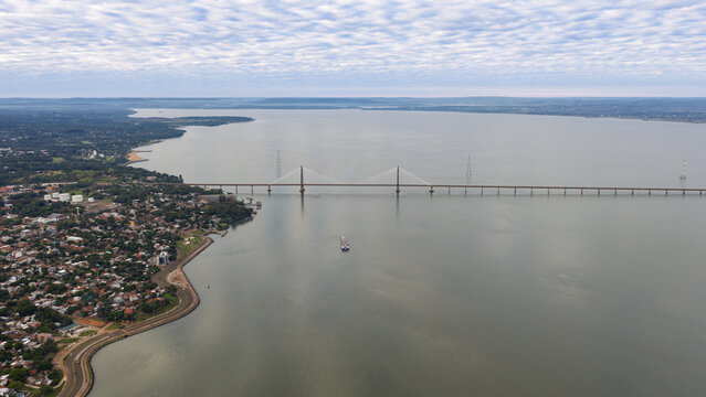 Grain barge navigating the Paran&aacute; River beneath San Roque Gonz&aacute;lez Bridge between Argentina and Paraguay.