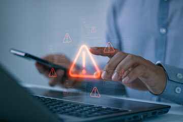 Businessman respond to digital security alert on laptop and smartphone, cybersecurity warning,...