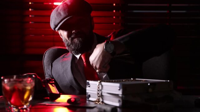 Mafia. Man with cigar throwing dollar banknotes and pointing gun at table in dark room. Camera moving