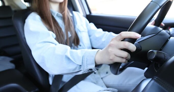 Woman driving car, closeup of hands on steering wheel