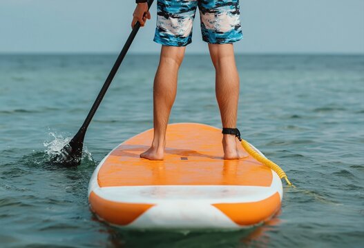 Person paddle boarding on calm ocean water