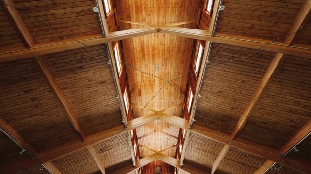 Low angle view of vaulted wooden ceiling in modern rustic building interior.