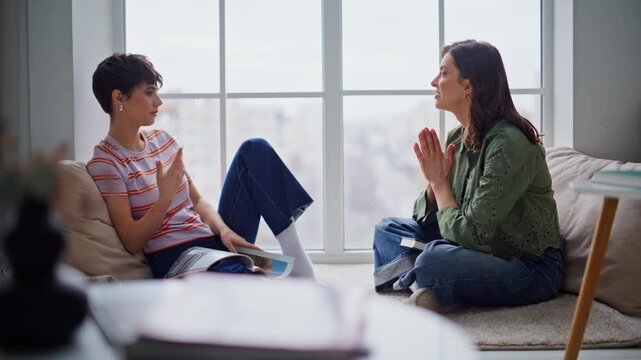 Attentive woman listening bestie sharing thoughts telling story on home floor.