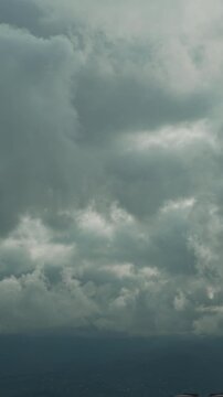 Storm warning, climate change vertical video, environmental protection. Timelapse of clouds sky are scudding over mountains. Problem of urban air pollution