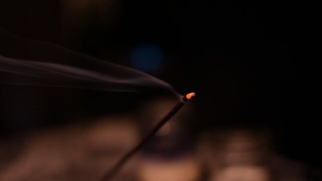 Dim location setting with a single incense burning.