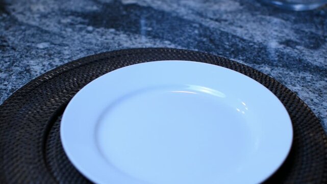 White plate on a silver granite surface. 