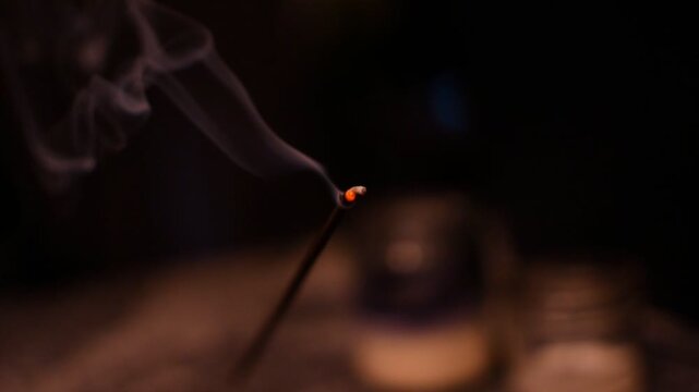 Lit incense burning with smoke from a close up view point. 