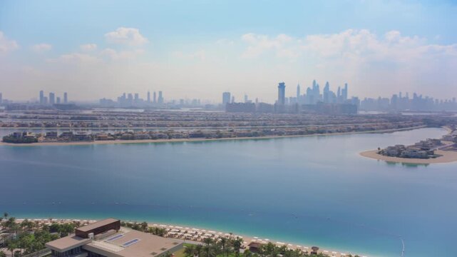 Breathtaking aerial view of Palm Jumeirah in Dubai featuring turquoise waters, sandy beaches, luxury resort properties with pools.