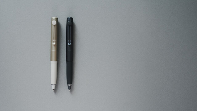 Two Elegant Pens Side by Side on Gray Background, Minimalist Stationery Flatlay