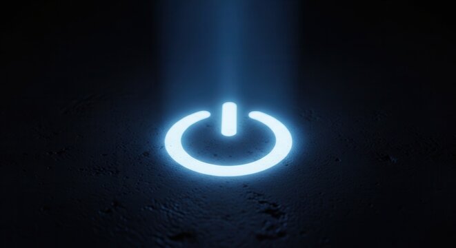 Glowing blue power button symbol illuminated by a beam of light on a dark background.