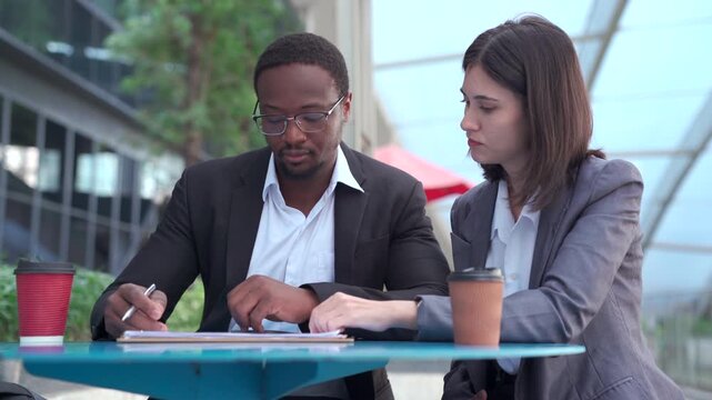 Diverse business partners discussing a project outside office