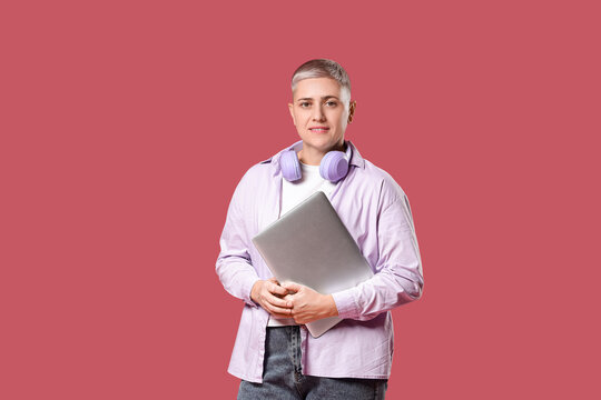 Female programmer with laptop on red background