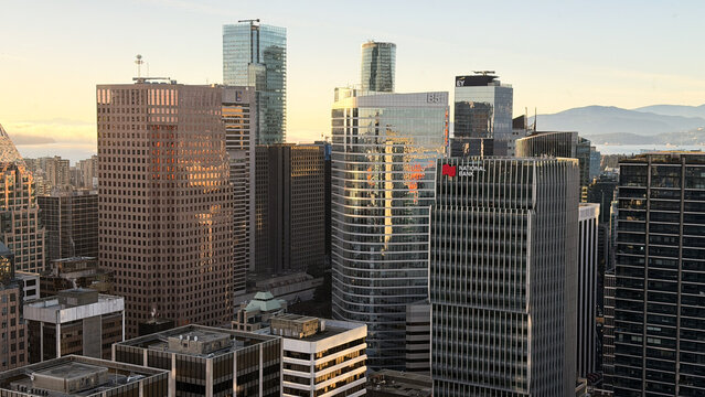Vancouver , Canada - January 2026: Downtown Vancouver skyline at golden hour with National Bank, EY, and BBH office towers against Burrard Inlet and North Shore mountains