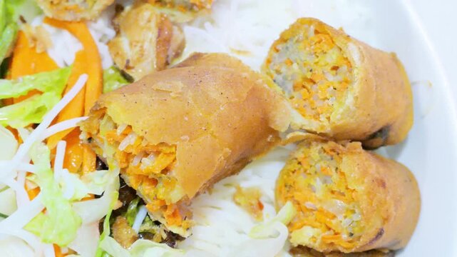 Sliced crispy fried Vietnamese egg roll over rice vermicelli noodle