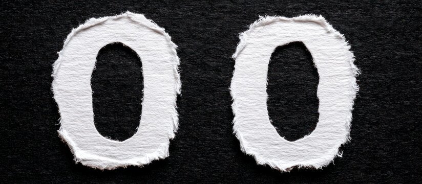 Two torn paper Os on a black background.
