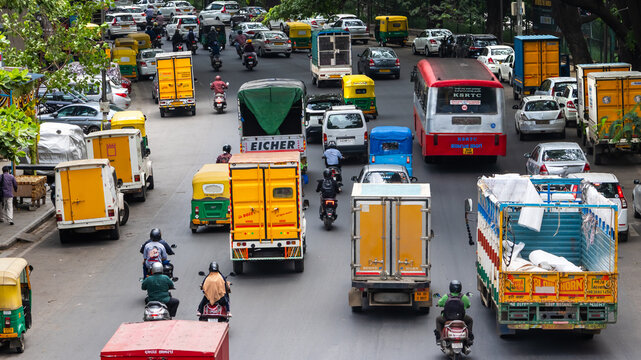 Bangalore street traffic with various vehicles moving irregularly including KSRTC bus, Eicher truck and Bajaj Tuktuks.