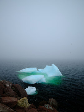 Beautiful iceberg floats in the fog and mist of Twillingate Harbor of Newfoundland-Labrador