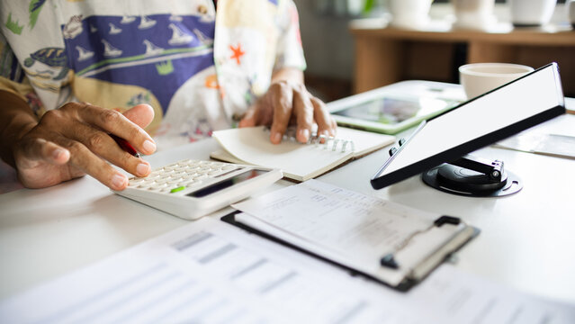 close-up shot, casual man working at home using wireless technology to start new business online, E-commerce via digital tablet, calculate business cost