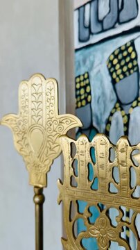 Traditional golden hamsa hand decoration and abstract painting at five star luxury hotel interior. Premium oriental interior design, arabian culture details and exotic resort styling.