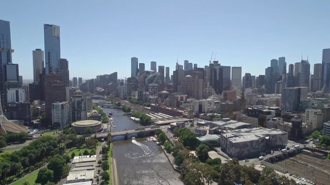 Aerial view of Melbourne skyline and Yarra river under clear blue sky with city buildings and bridges.