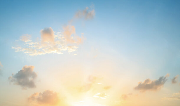 Beautiful bright golden sunset sky background with vibrant blue and romantic orange clouds for inspirational nature wallpaper panorama