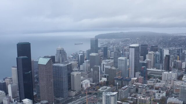 Aerial view of a vibrant seattle city skyline, capturing the urban landscape and majestic puget sound on a cloudy day.