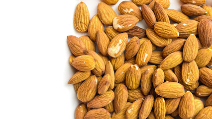 Fototapeta premium Raw almonds scattered on a white background in a clean minimal composition. Natural healthy snack ingredient shown in a top view with visible nut texture