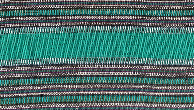 A striped woven fabric texture with a combination of turquoise, black, white, and purple. Suitable for backgrounds, textile patterns, ethnic design, wallpaper, fashion, and modern traditional decor.