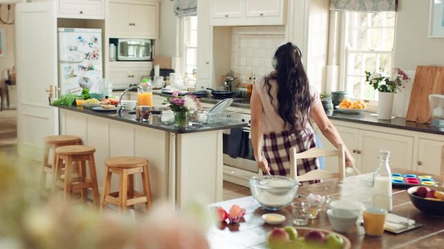 Woman, headphones and dance with spoon in kitchen, meal prep and move with energy in house or silly. Happy person, singing and rhythm with phone for music, cooking and celebration with tech in home