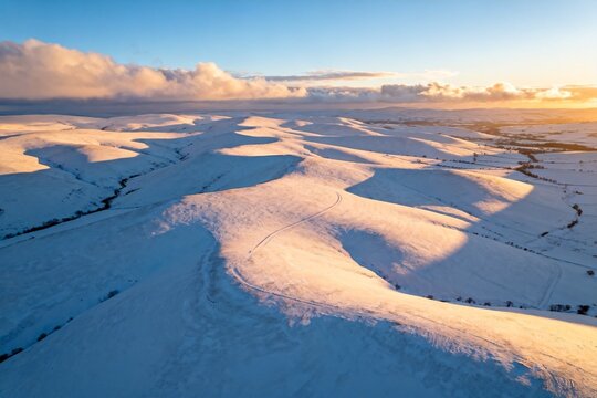 Snowy rolling hills at sunset