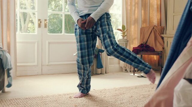 Dancing, movement and legs of man in home for celebration, performance or practice. Happy, excited and male person with expression for hip hop rhythm, entertainment and morning fun in pyjamas