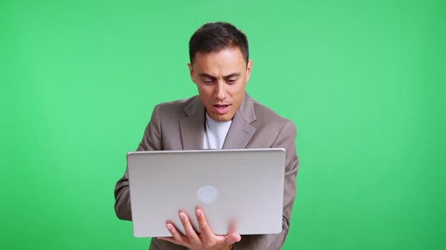 Frustrated businessman using laptop then smiling on green screen