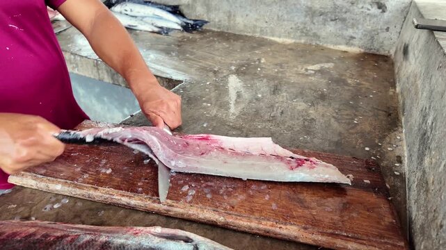 Close up of fish filleting process by local fishmonger at seafood market
