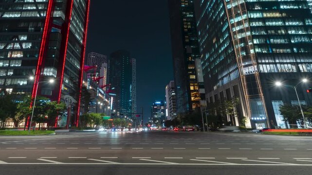 A captivating nighttime time-lapse of a busy city intersection where cars create mesmerizing light trails and skyscrapers gleam with illuminated windows.
