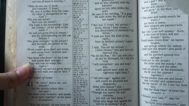 Holy Bible open up to the book of Isaiah of the old testament, zooming into Chapter 41 verse 10 on not being fearful because God is with you. New Intenational