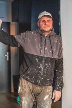 Portrait of a tired mature construction worker or painter returning home after a hard day of work