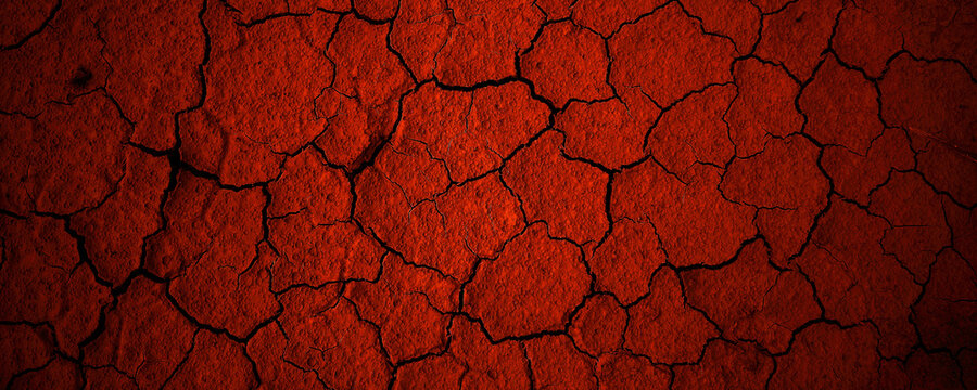 Rough, dry red earth texture, cracked patterns in a desert landscape. Perfect for background in drought, climate, nature concepts.