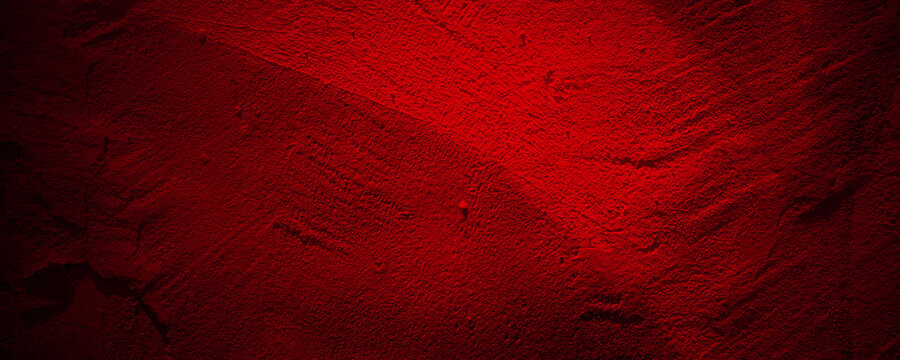 Bright crimson textured paint surface with dark shadows and dramatic lighting on a deep maroon colored wall. Suitable for backgrounds or abstract art projects.