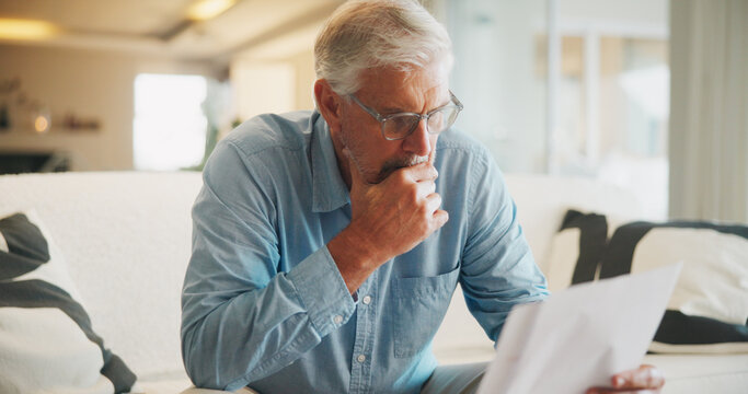 Reading, paperwork and old man with stress, thinking or confused for insurance or bills in home. Policy, pension documents and senior person on sofa with worry or decision for financial report