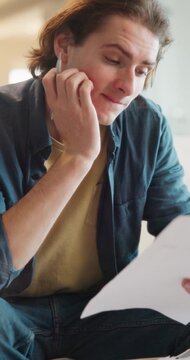 Man, paperwork and stress in home for debt, eviction letter or financial decision on sofa. Worried, mistake and person with anxiety, risk and documents for budget, mortgage or loan rejection