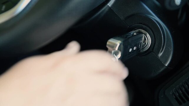 Driver starting car engine with ignition key