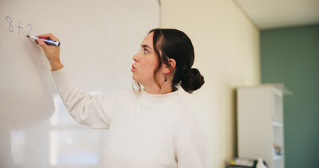 Writing, teacher or woman with whiteboard in class, addition lesson or math syllabus for learning. Teaching, education or educator with explanation for problem solving, knowledge or elementary school © peopleimages.com