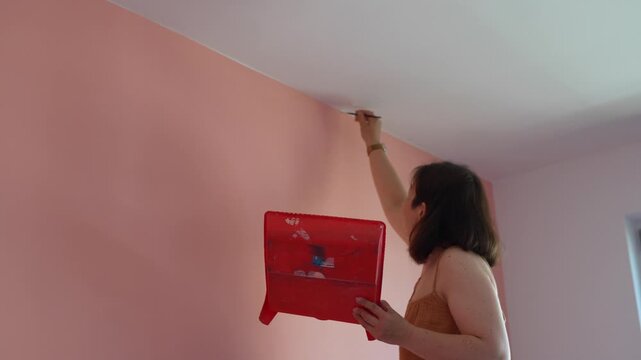 Woman 40 yo paints walls in her home